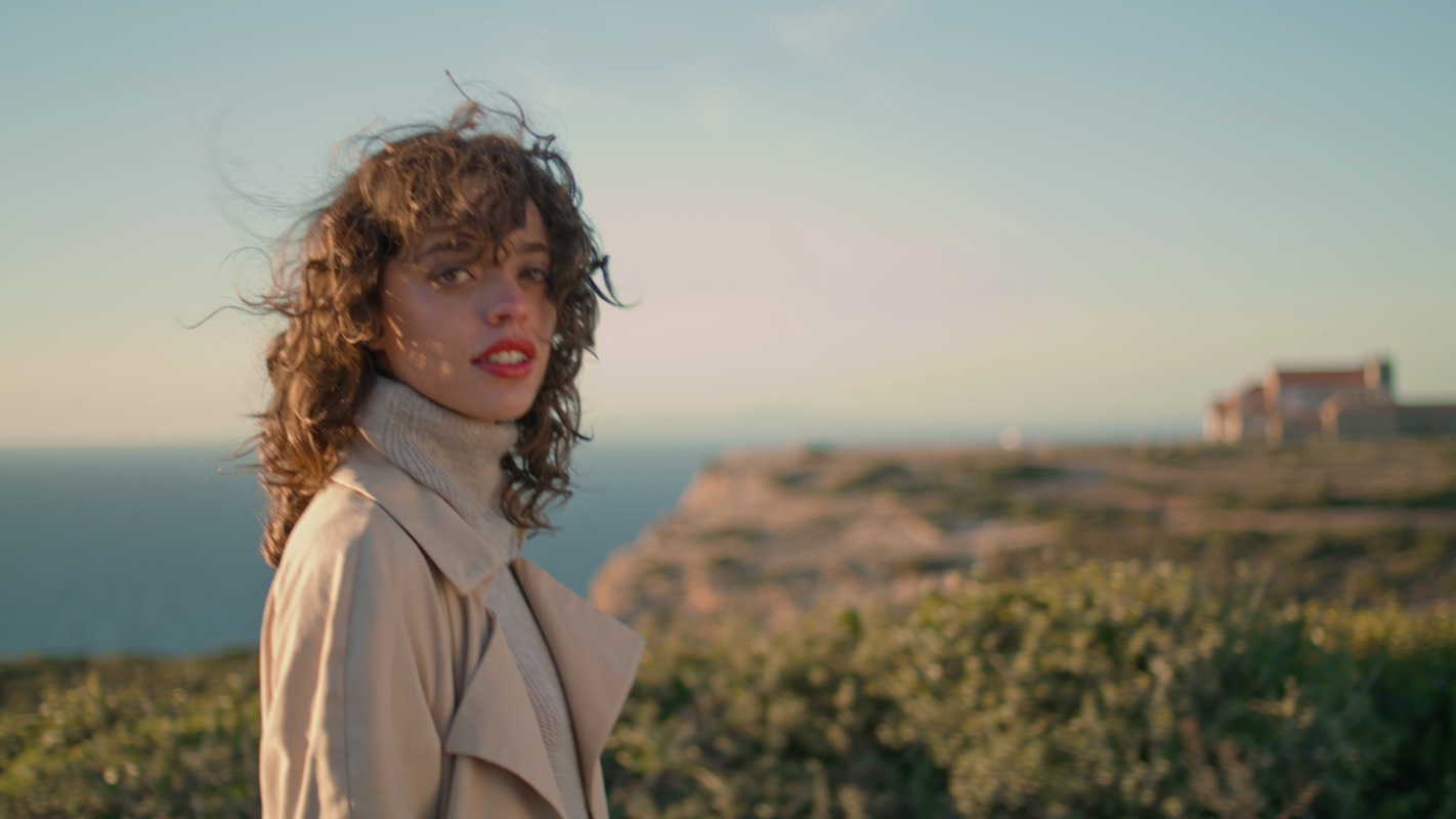 A woman by the ocean at golden hour